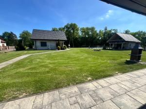 a large yard with a house and a building at Domki letniskowe Malina 4 in Gawrony