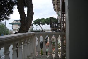 a balcony with a white railing and a tree at Casa Selly in Loano