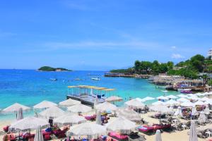 a beach with a bunch of umbrellas and the ocean at Mandi's Apartment in Ksamil