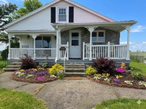 a small house with flowers in the front yard at Peaceful Pasture Farm in Fort Edward