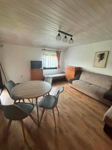 a living room with a table and chairs and a couch at Domki letniskowe u Marty in Łeba