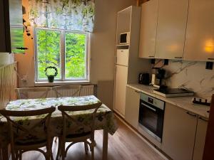 a kitchen with a table with chairs and a window at VILLA ANNA in Naantali