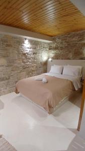 a bed in a room with a stone wall at cozystudio Chezmoi in Chios