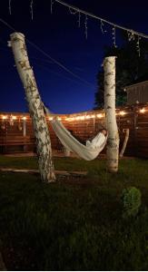 a woman sleeping in a hammock in a yard at night at The Doma in Oral