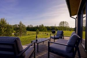 a patio with a table and chairs and a view of a field at Lapės Kalva in Rimėnai
