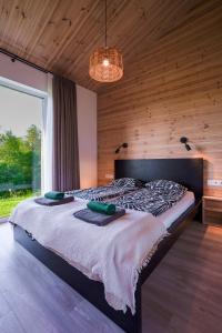 a large bed in a room with a large window at Lapės Kalva in Rimėnai