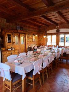 a large room with a long table with white tables and chairs at St.Michael Panzió Lovaspark in Vasszentmihály +13 photos