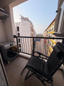a balcony with a chair and a television on a building at Jula Hearth 1BHK in Chicalim