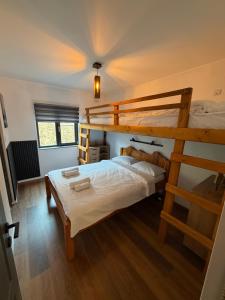 a bedroom with two bunk beds and a ladder at Greystone Cabin in Măguri-Răcătău