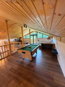 a pool table in a room with a ceiling at Greystone Cabin in Măguri-Răcătău