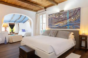 a bedroom with a bed and a painting on the wall at PALMASERA CHARMING - Rooms & Suites in Cala Gonone