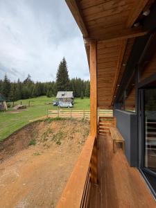 a porch of a house with a view of a field at Greystone Cabin in Măguri-Răcătău