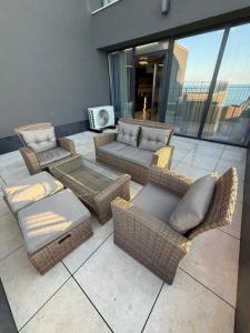a patio with wicker chairs and couches on a building at Luxe 1 apartments in Obzor