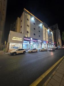 a group of cars parked on a city street at night at فندق مواسم الخير in Al ‘Azīzīyah