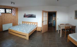 a bedroom with a bed and a table and a dining room at Penzion Panter in Horní Planá +54 photos