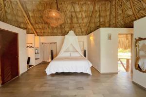 a bedroom with a bed in the middle of a room at Akalki Hotel y Centro Holistico in Bacalar