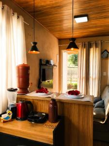 a kitchen with a counter and a window at Chalé Romântico Privativo com Lareira e vista para Montanhas in Capela do Alto
