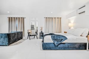 a bedroom with a large bed with a blue couch at Hotel Harrison On the Beach in Miami Beach