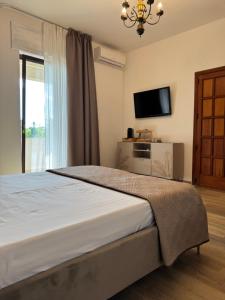 a bedroom with a bed with a television and a window at Chilometro Mille Suites e Apartments in Otranto