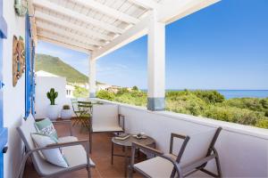 a balcony with chairs and a view of the ocean at PALMASERA CHARMING - Rooms & Suites in Cala Gonone