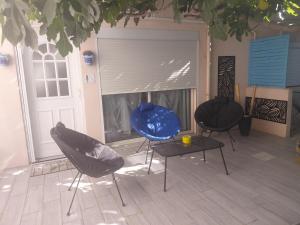 two chairs and a table in front of a door at chambre d 'hôtes les Orchidées in Perpignan