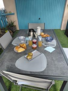 a table with plates of food and drinks on it at chambre d 'hôtes les Orchidées in Perpignan +2 photos