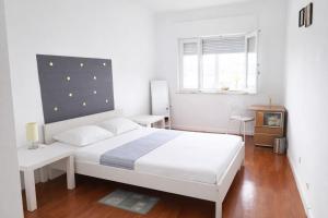 a white bedroom with a white bed and a window at Estádio da Luz Room in Lisbon