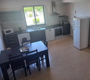 a small kitchen with a table and a refrigerator at Maroiço Residence in Madalena +18 photos