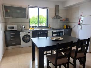 a kitchen with a table and chairs in a kitchen at Maroiço Residence in Madalena
