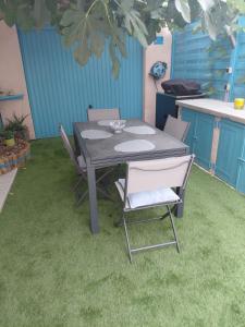 a table and chairs on the grass in a kitchen at chambre d 'hôtes les Orchidées in Perpignan