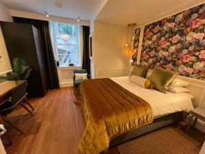 a bedroom with a large bed with a floral wall at Ferndale Mews in Bristol