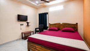 a bedroom with a large bed and a tv at Sai krishna residency in Pithāpuram