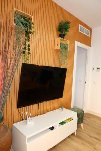 a living room with a flat screen tv on a wall at Divi Apartments Costa Ballena in Costa Ballena