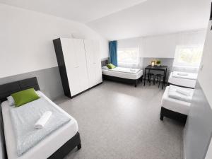 a room with two beds and a table in it at Grey Poznań Pokój z łazienką, Free Parking & Self Check-in in Poznań
