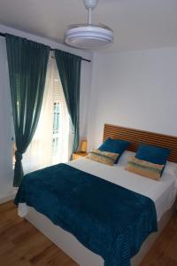 a bedroom with a large bed with blue sheets and a window at Divi Apartments Costa Ballena in Costa Ballena +24 photos
