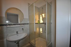 a bathroom with a shower and a sink and a mirror at Gästehaus Brinkmann am Moor in Spenge