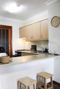 a kitchen with a counter and two wooden stools at Sueños de Tabaiba y Mar in Tabaiba