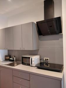 a kitchen with a microwave and a sink at TML Parkview Apartment in Boom