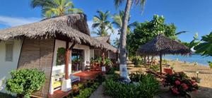 a house on the beach with a view of the ocean at Long Beach Resort, Nosy Be in Nosy Be