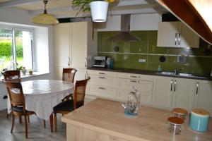 a kitchen with a table and chairs and a sink at maison pour vieilles charrues in Maël-Carhaix