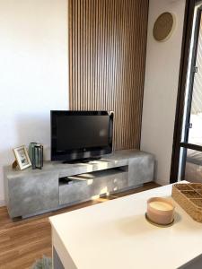 a living room with a flat screen tv on a entertainment center at Cute get away apartment RBLD in La Mata