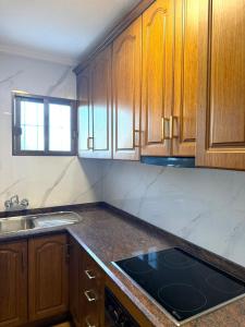 a kitchen with wooden cabinets and a stove top at Cute get away apartment RBLD in La Mata