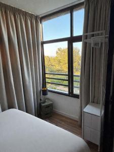 a bedroom with a bed and a large window at Cute get away apartment RBLD in La Mata