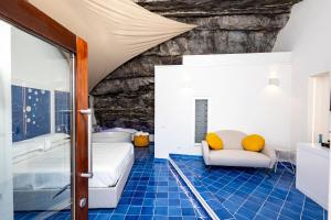 a bedroom with a bed and a chair in a room at Le Suite dei Pescatori in Praiano
