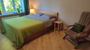 a bedroom with a bed and a chair at Viļāni Nākotnes in Viļāni