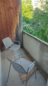 two chairs sitting on a porch looking out a window at Viļāni Nākotnes in Viļāni