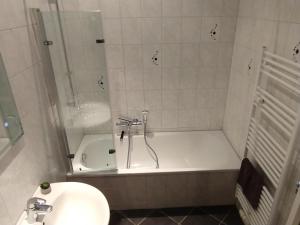 a bathroom with a tub and a toilet and a sink at Apartment Zur Bauhütte, WLAN in Hohenstein-Ernstthal