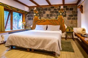 a bedroom with a large bed and a stone wall at Casa Primal in San José de Maipo +33 photos