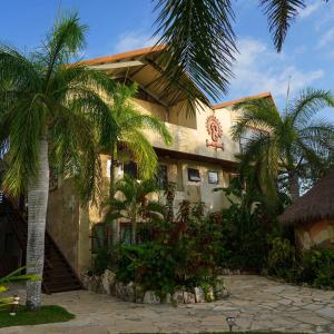 a building with palm trees in front of it at Akalki Hotel y Centro Holistico in Bacalar