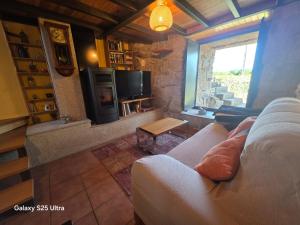 a living room with a couch and a tv at La casa de arriba in Ourense